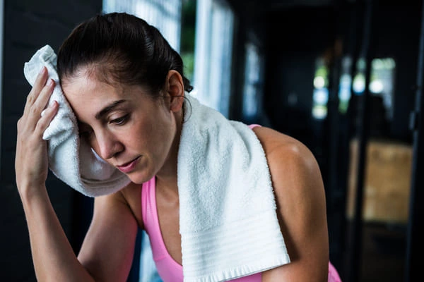 Hiperhidrosis en mujer preocupada por sudoración excesiva en el GYM - Colombia No Sweat